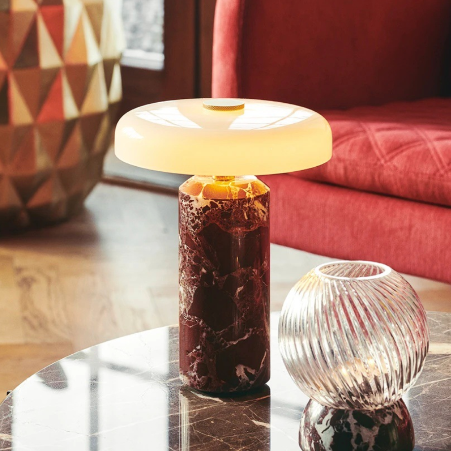 Table lamp with marble base on a round table in a living room setting