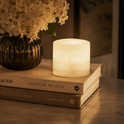 Lamp on books with a vase of flowers in the background