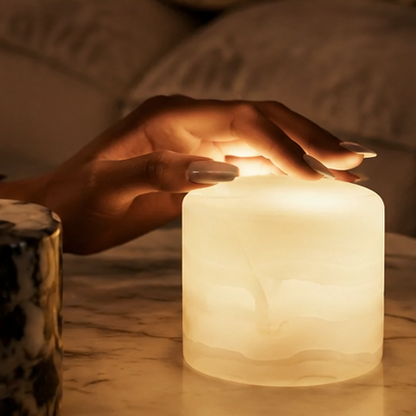 Collage of a candle in various settings, including a table and a living room.