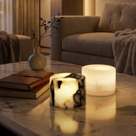 Decorative candles on a marble table in a cozy living room setting.