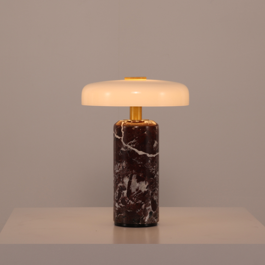 Table lamp with marble base and white shade on a neutral background