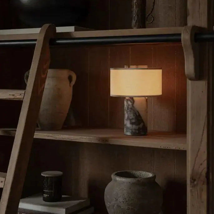 Wooden shelf with decorative items including a lamp, books, and vases.